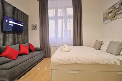 a bedroom with a large bed and a couch at Modern apartment in the heart of Prague in Prague