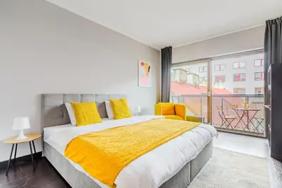 a bedroom with a large bed and a balcony at Deluxe apartments near center Prague in Prague