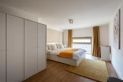 a white bedroom with a bed and a window at Deluxe apartments near center Prague in Prague