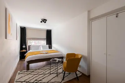 a bedroom with a bed and a chair at Deluxe apartments near center Prague in Prague