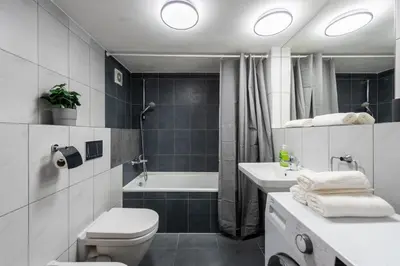 a bathroom with a toilet and a tub and a sink at Deluxe apartments near center Prague in Prague