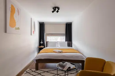a small bedroom with a bed and a chair at Deluxe apartments near center Prague in Prague