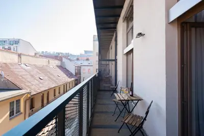 a balcony with chairs and tables on a building at Deluxe apartments near center Prague in Prague