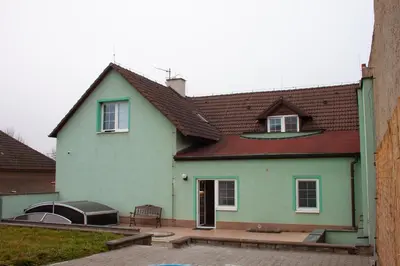 a bedroom with a bed and a futon at Podkrovní apartmán se společným bazénem in Zlonice