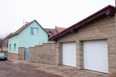 a kitchen with white cabinets and a washer and dryer at Podkrovní apartmán se společným bazénem in Zlonice