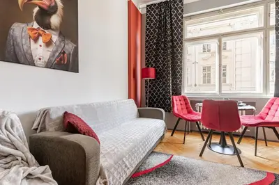 a living room with a couch and red chairs at Place of Grace - 1 min to National Theatre in Prague
