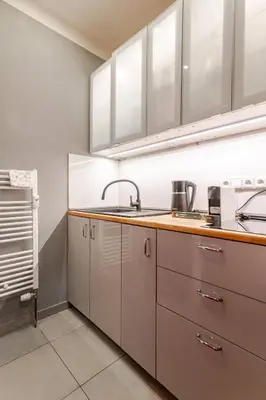 a kitchen with white cabinets and a sink at Place of Grace - 1 min to National Theatre in Prague