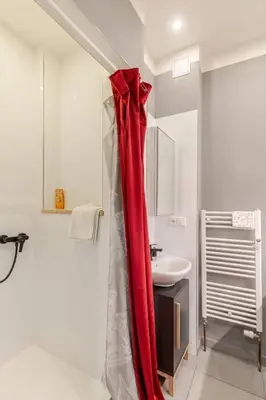 a red shower curtain in a bathroom with a sink at Place of Grace - 1 min to National Theatre in Prague
