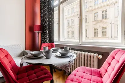 a dining room with a table and two chairs and a window at Place of Grace - 1 min to National Theatre in Prague