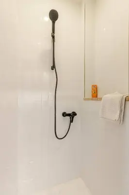 a shower with a black shower head in a bathroom at Place of Grace - 1 min to National Theatre in Prague