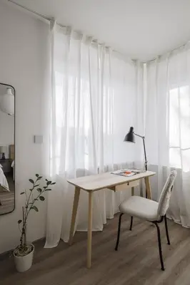 a desk and a chair in a room with white curtains at Spacious 4-Story Home with Sauna & Garden in Prague