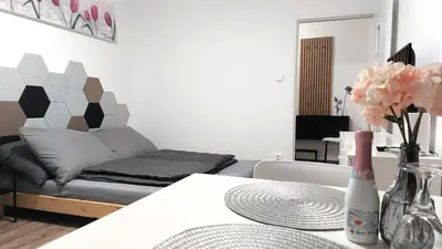 a living room with a couch and a table with flowers at Pretty private Apartment U LABE, self-service check-in 24 l 7 in Neratovice