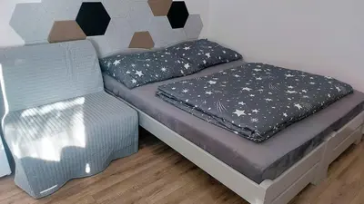 a bedroom with a bed and a chair in it at Pretty private Apartment U LABE, self-service check-in 24 l 7 in Neratovice