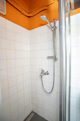 a shower in a bathroom with white tiles at Grand apartment near Dancing House in Prague