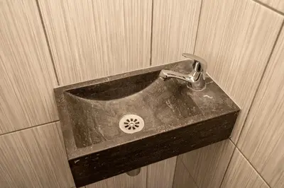 a bathroom sink with a faucet on a wall at Grand apartment near Dancing House in Prague