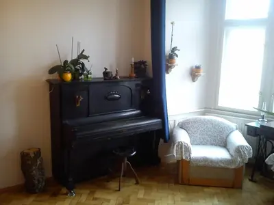 a room with a black stove and a chair and a window at Rain Man's Apartment in Prague