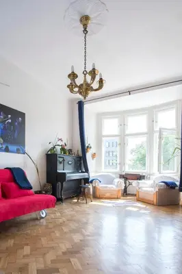 a living room with a red couch and a chandelier at Rain Man's Apartment in Prague