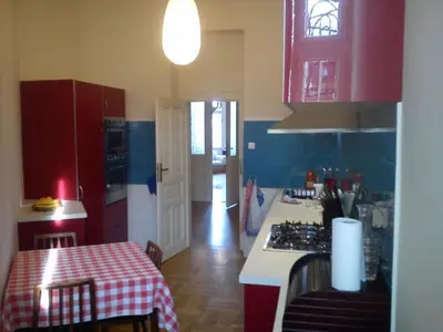 a kitchen with red cabinets and a table with a table cloth at Rain Man's Apartment in Prague