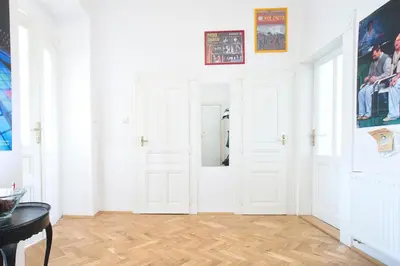 a white room with white doors and wooden floors at Rain Man's Apartment in Prague