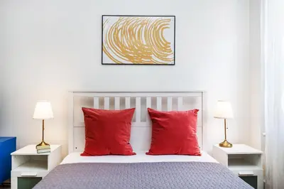 a bedroom with a bed with two red pillows at Prague Days - Old Town Apartments in TOP location in Prague