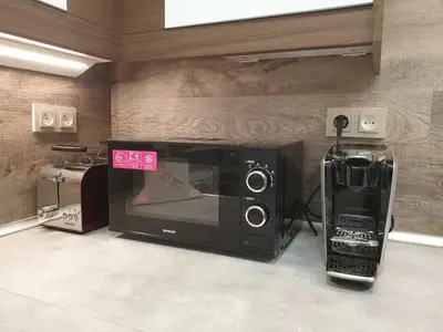 a microwave oven with a sign in a room at Apartmán U Labe in Nymburk