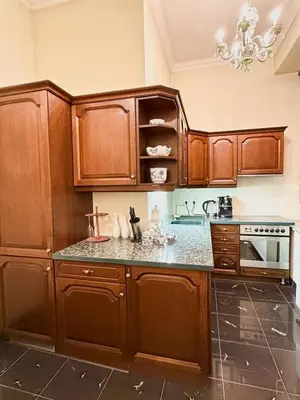 a kitchen with wooden cabinets and granite counter tops at Monarch Casa Residence XXL 137m2 in Prague