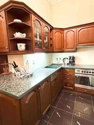 a kitchen with wooden cabinets and granite counter tops at Monarch Casa Residence XXL 137m2 in Prague