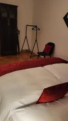 a bedroom with a bed with a red blanket and a chair at Premium Apt - Center of Prague in Prague