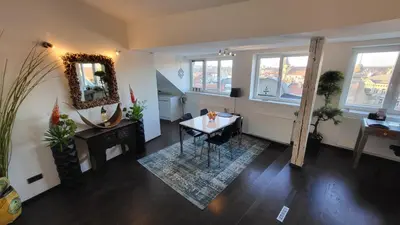a living room with a table and a mirror at Luxury Apt - View of the Center of Prague in Prague