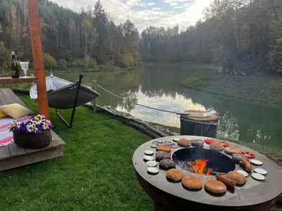 a table with food on it next to a lake at Glamp SunnyMoon in Sudoměř