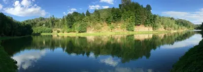 a river with a reflection of trees in the water at Glamp SunnyMoon in Sudoměř