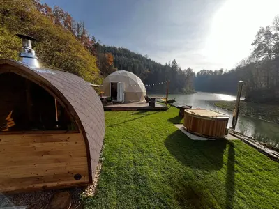 a yurt and a boat on the grass next to a lake at Glamp SunnyMoon in Sudoměř