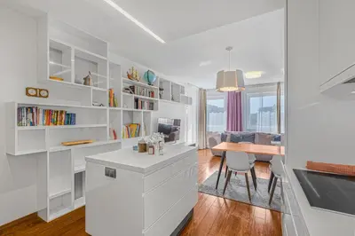 a kitchen with white cabinets and a desk and a table at New large apartment, Free Parking! in Prague