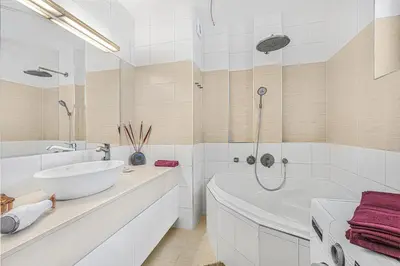 a white bathroom with a tub and a sink at New large apartment, Free Parking! in Prague