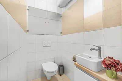 a white bathroom with a toilet and a sink at New large apartment, Free Parking! in Prague