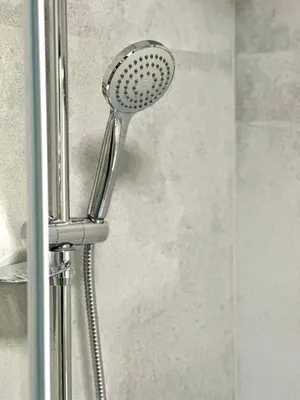 a shower head is attached to a glass door at 1BDR Dazzling Apartment only 8 min to Wenceslas Square in Prague