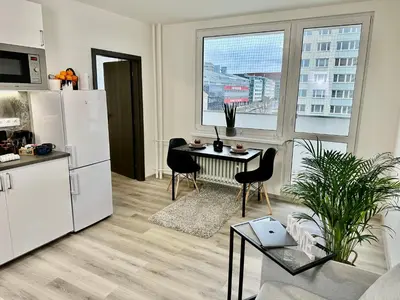 a kitchen and living room with a table and chairs at 1BDR Dazzling Apartment only 8 min to Wenceslas Square in Prague