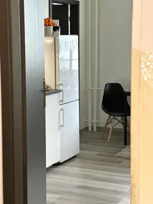 a refrigerator in a room with a table and a chair at 1BDR Dazzling Apartment only 8 min to Wenceslas Square in Prague