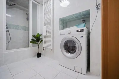 a washing machine in a bathroom with a shower at Prague Days - Loft-style One-bedroom Apartment in the City Center in Prague
