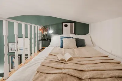 a bedroom with a large bed with a book on it at Prague Days - Loft-style One-bedroom Apartment in the City Center in Prague