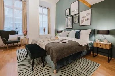 a bedroom with a large bed and a chair at Prague Days - Loft-style One-bedroom Apartment in the City Center in Prague