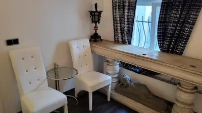 a dining room with two chairs and a wooden table at Luxury Apt - Free Massages from Physiotherapists in Prague