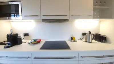 a kitchen with white cabinets and a counter top at Luxury Apt - Free Massages from Physiotherapists in Prague