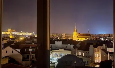a view of a city at night from a window at Luxury Apt - Free Massages from Physiotherapists in Prague