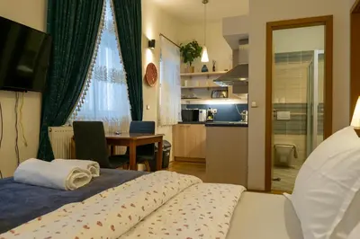 a bedroom with a bed and a table and a kitchen at Cozy retreat in the Old Town in Prague