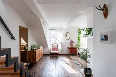 a living room with a staircase and a chair at Charming Prague Apartment in Vrovice with Roof Terrace in Prague