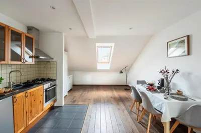 a kitchen and dining room with a table and chairs at Charming Prague Apartment in Vrovice with Roof Terrace in Prague
