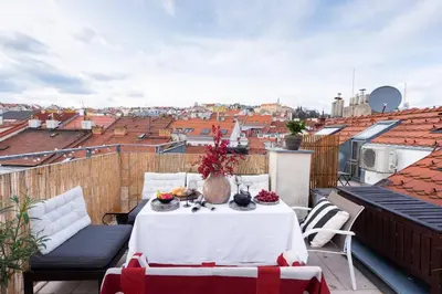 a table on a balcony with a view of the city at Charming Prague Apartment in Vrovice with Roof Terrace in Prague