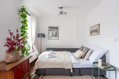 a small bedroom with a bed and a table at Charming Prague Apartment in Vrovice with Roof Terrace in Prague
