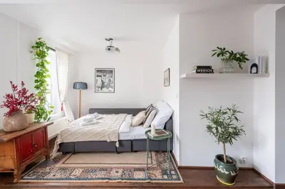 a bedroom with a bed and a window with plants at Charming Prague Apartment in Vrovice with Roof Terrace in Prague